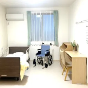 居室の中の様子。ベッド、車椅子、机、本棚などがある